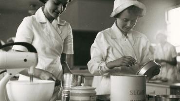 These two girls may be whipping up a cake or a sponge. During the 1950s girls taking part in cooking classes wore nurse-like white uniforms with caps. Bathurst High School, 1954. Digital ID 15051_a047_000772 These two girls may be whipping up a cake or a sponge. During the 1950s girls taking part in cooking classes wore nurse-like white uniforms with caps. Bathurst High School, 1954. Digital ID 15051_a047_000772