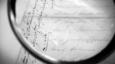 Black and white magnifying glass over paper record